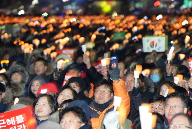 박근혜 대통령 탄핵소추안이 가결된 다음 날인 10일 광화문 광장에 모인 시민이 촛불을 밝히고 '박근혜 대통령 즉각 퇴진' 구호를 외치고 있다. 왕태석기자 kingwanag@hankookilbo.com