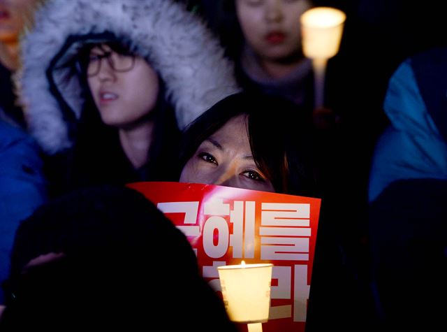 박근혜 대통령 탄핵소추안이 가결된 다음 날인 10일 광화문 광장에 모인 시민이 촛불을 밝히고 있다. 왕태석기자 kingwanag@hankookilbo.com