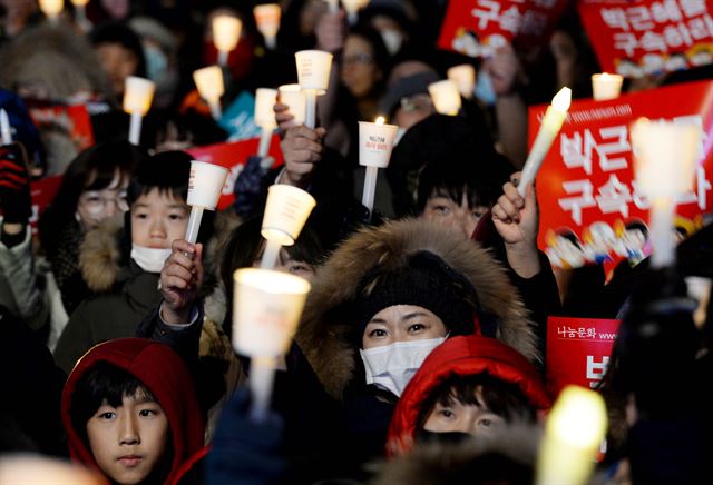 박근혜 대통령 탄핵소추안이 가결된 다음 날인 10일 광화문 광장에 모인 시민이 촛불을 밝히고 '박근혜 대통령 즉각 퇴진' 구호를 외치고 있다. 왕태석기자kingwanag@hankookilbo.com