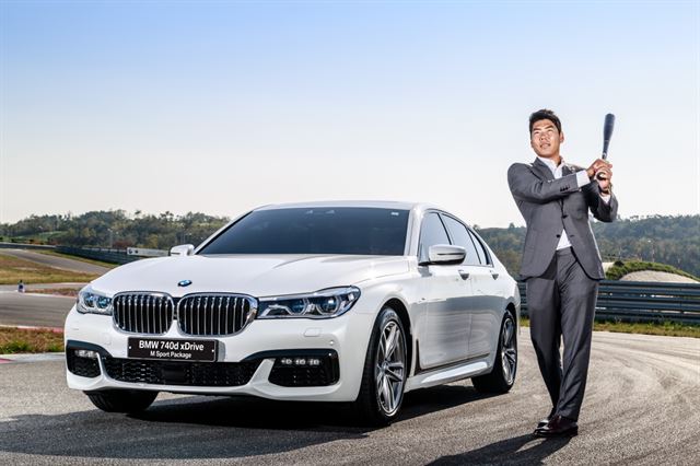 강정호 선수가 BMW 740d M 스포츠 패키지 옆에서 야구 배트를 휘두르고 있다. BMW코리아 제공