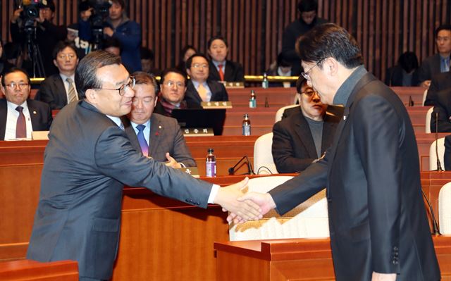 새누리당 이정현 대표가 14일 오전 국회에서 열린 의원총회에서 사의를 밝힌 정진석 원내대표가 발언을 마친 후 내려오자 악수를 청하고 있다. 연합뉴스