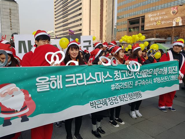 17일 서울 광화문광장에서 열린 박근혜퇴진청년산타대작전에 참석한 청년들이 행진하고 있다. 김정현 기자