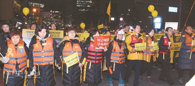 17일 제8차 촛불집회에 참석한 세월호 유가족들이 참사 희생자들을 기리고 국가 대응에 대한 책임을 묻는 뜻으로 구명조끼를 입고 서울 광화문광장에서 삼청동 국무총리공관을 향해 행진하고 있다. 배우한 기자