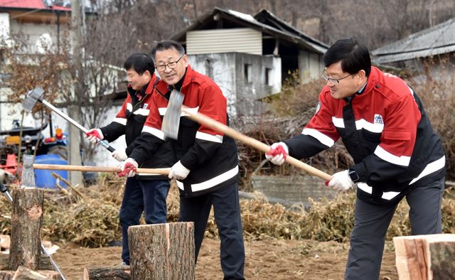 신원섭(오른쪽) 산림청장이 19일 충주시에서 직원들과 함께 농ㆍ산어촌 저소득층 주민에게 사랑의 땔감으로 전달할 장착을 패고 있다. 산림청 제공