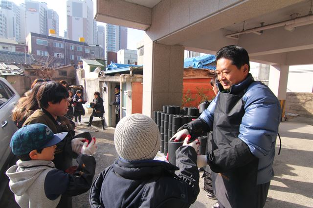 수성구초등학교운영위원장협의회O·B 회원들과 어린이 봉사자들이 대구 수성구 수성4가 독거노인을 찾아 겨울나기를 위한 연탄을 나르고 있다. 김민규기자 whitekmg@hankookilbo.com