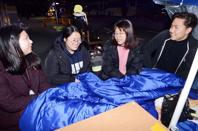 노숙농성 1년을 맞은 ‘대학생 소녀상 지킴이’ 김소민(왼쪽부터) 김지윤 이소영씨와 본보 김정현 기자가 14일 밤 서울 종로구 일본대사관 앞에서 일본군위안부 문제의 해결 방안을 이야기 하고 있다. 고영권 기자