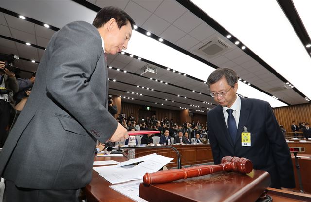 우병우 전 청와대 민정수석이 22일 오전 국회에서 열린 박근혜 정부의 최순실 등 민간인에 의한 국정농단 의혹사건 진상규명을 위한 국정조사 5차 청문회에서 증인선서를 마친 뒤 선서문을 김성태 위원장에게 제출하고 있다. 2016.12.22 오대근기자