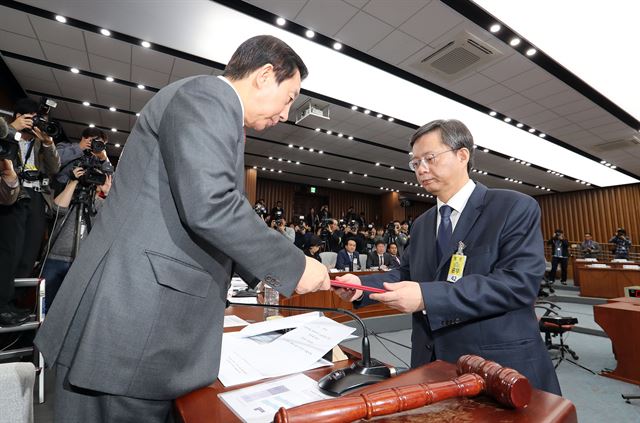 우병우 전 청와대 민정수석이 22일 오전 국회에서 열린 박근혜 정부의 최순실 등 민간인에 의한 국정농단 의혹사건 진상규명을 위한 국정조사 5차 청문회에서 증인선서를 마친 뒤 선서문을 김성태 위원장에게 제출하고 있다. 연합뉴스