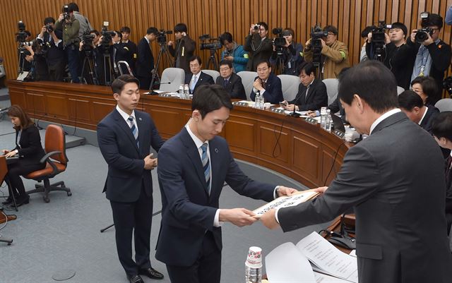 22일 오전 국회에서 열린 박근혜 정부의 최순실 등 민간인에 의한 국정농단 의혹사건 진상규명을 위한 국정조사 5차 청문회에서 김성태 위원장이 국회 사무처 직원들에게 최순실·안종범·정호성 등 불출석 증인에 대한 동행명령장을 발부하고 있다. 연합뉴스