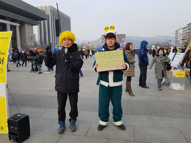 시민단체 환경운동연합 회원들이 24일 오후 녹색 산타로 분장하고 헌법재판소에 탄핵인용을 촉구하는 엽서 보내기 행사를 진행하고 있다.