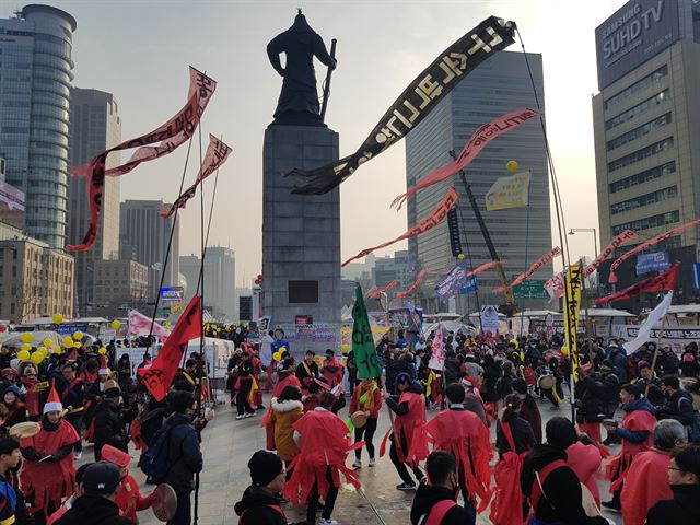 전국풍물인연석회의 소속 회원 50여명이 24일 오후 서울 광화문광장에서 산타로 분하고 도깨비굿을 선보이고 있다. 한 회원은 “진도 도깨비굿은 마을에 전염병이 돌 때 하는 굿”이라며 “올해의 액운을 떨쳐내고 희망찬 새해를 맞이하자는 의미를 담았다”고 설명했다.