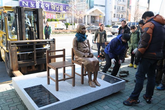 ‘미래세대가 세우는 평화의 소녀상 추진위원회ㆍ서포터즈’가 30일 오후 부산 동구청에서 돌려 받은 평화의 소녀상을 동구 초량동 일본영사관 인근 보행로에 다시 세우고 있다.