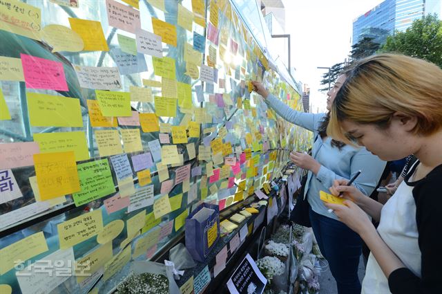 지난 5월 18일 여성들이 서울 강남역에서 '묻지마 살인' 희생자를 추모하는 글을 붙이고 있다. 신상순 선임기자 ssshin@hankookilbo.com