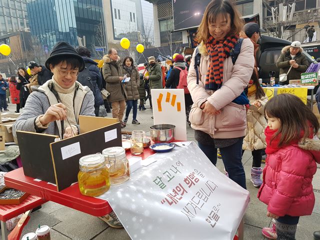 31일 오후 서울 광화문광장에서 이장욱 현대미술작가가 달고나에 내년의 희망을 새겨주는 퍼포먼스를 진행했다. 가장 인기 있는 문구는 '사랑'과 '희망'이었다. 김정현 기자