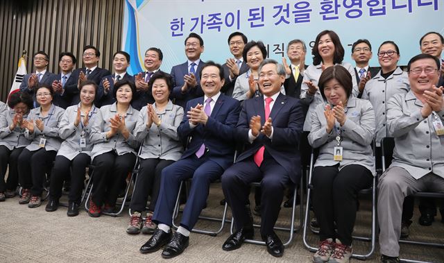 정세균 국회의장이 2일 오전 국회에서 열린 '국회 청소근로자' 직접고용 기념 신년행사에서 근로자 대표에게 국회 직원 신분증을 전달한 뒤 기념촬영을 하고 있다. 비정규직 파견업체직원이었던 국회 환경미화원들은 정 의장이 취임한 뒤 직접 고용 의사를 밝혀 정부와의 관련 협의를 거쳐 이날부터 국회의 정식직원이 됐다. 2017.1.2 연합뉴스