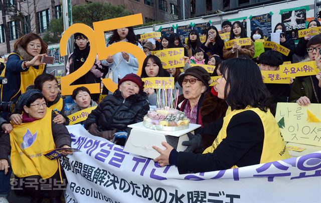 [저작권 한국일보]4일 서울 종로구 중학동 옛 일본대사관 앞에서 열린 제1264차 일본군 위안부 문제해결을 위한 정기 수요시회에서 길원옥 할머니와 김복동 할머니, 윤미향 정대협 상임대표등 참석자들이 25주년 기념 떡케익의 촛불 을 끄고 있다. 1992년 1월 8일 시작된 수요집회는 올해로 25주년을 맞았다.2017.01.04 신상순 선임기자ssshin@hankookilbo.com /2017-01-04(한국일보)