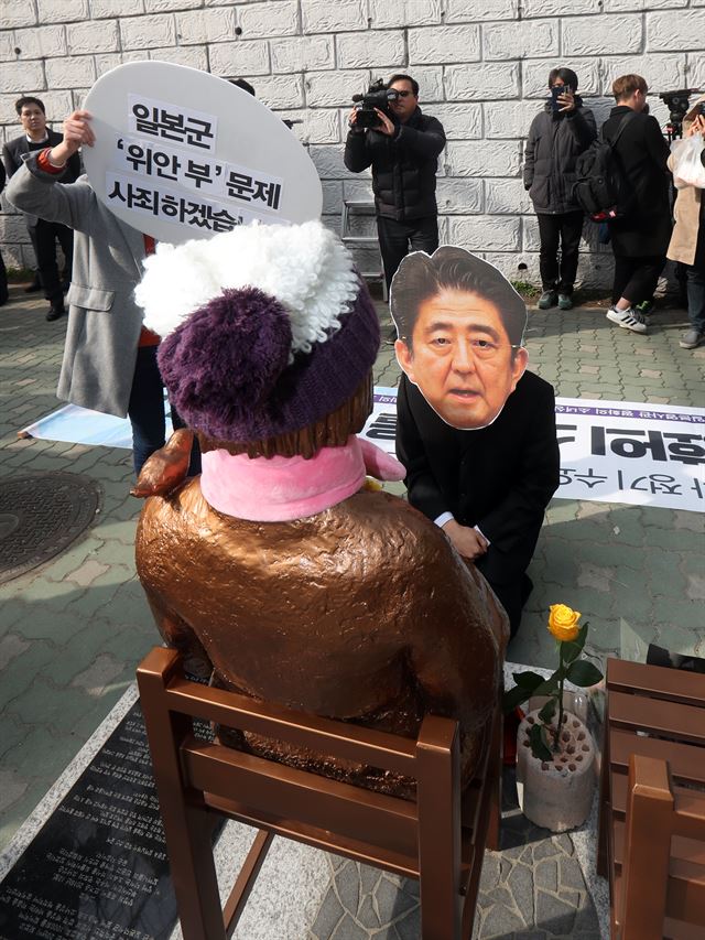 지난 4일 부산 동구 초량동 일본영사관 앞 소녀상에서 시민단체가 위안부 수요집회 25주년 기자회견을 마친 뒤 일본 아베 총리가 소녀상에 무릎 꿇고 사죄하는 퍼포먼스를 벌이고 있다. [부산=연합뉴스]