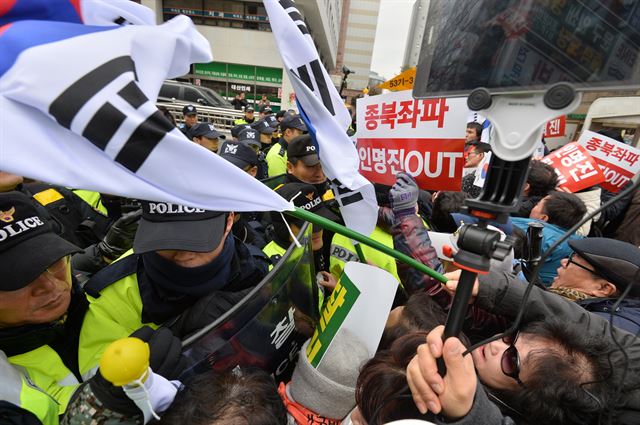 '대한민국애국시민연합' 등 보수단체 회원들이 8일 오후 서울 여의도 새누리당사 앞에서 인명진 비대위원장 사퇴를 촉구하는 집회를 열고 경찰과 몸싸움을 벌이며 태극기로 경찰을 가격하고 있다. 뉴시스