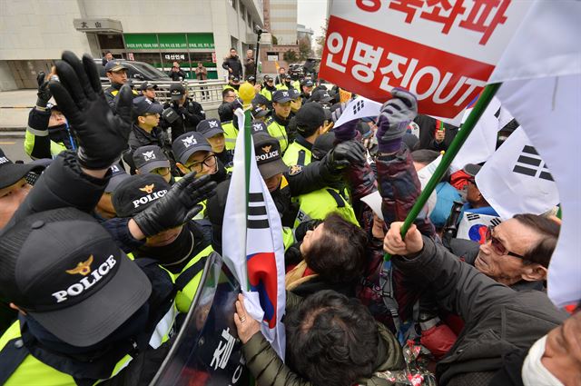 '대한민국애국시민연합' 등 보수단체 회원들이 8일 오후 서울 여의도 새누리당사 앞에서 인명진 비대위원장 사퇴를 촉구하는 집회를 열고 경찰과 몸싸움을 벌이며 태극기로 경찰을 가격하고 있다. 뉴시스