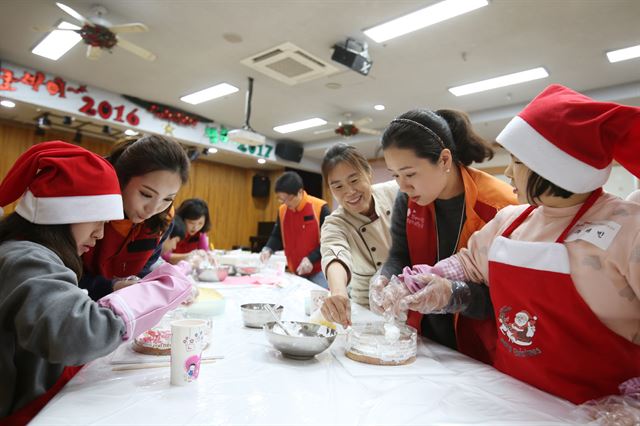 지난달 21일 서울 노원구 다운복지관을 방문한 SK이노베이션 직원들이 발달장애아동과 함께 크리스마스 케이크 만들기 체험을 하고 있다. SK이노베이션 제공