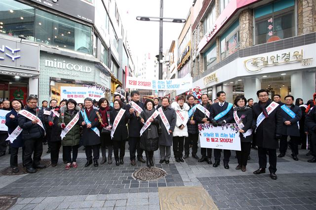 최문순 강원지사는 “강원상품 유통과 강원일자리안심 공제 등 서민경제 안정을 지원하기 위한 경제정책을 시행하겠다”고 밝혔다. 지난해 말 춘천 명동거리 일원에서 열린 소비촉진 캠페인 행사장에서 최 지사(왼쪽 네 번째)를 비롯한 지역 경제단체 관계자들이 기념촬영을 하고 있다. 강원도 제공