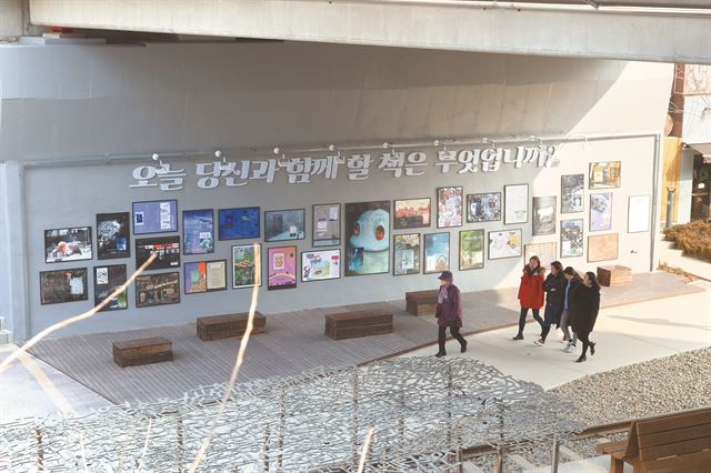 시민들이 10일 서울 마포구 와우교 밑에 책을 테마로 조성된 휴식공간을 지나가고 있다.