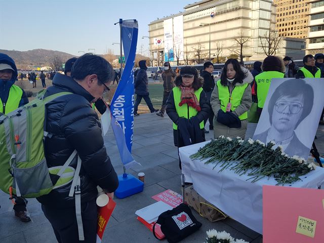 14일 서울 광화문광장에서 열린 고 박종철 열사 30주기 추모식에 참가한 한 시민이 박 열사의 사진 앞에서 묵념을 하고 있다. 김정현 기자