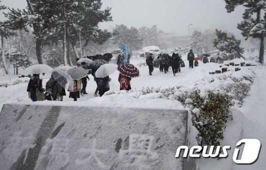 14일 눈 내리는 니가타현에서 학생들이 이동하고 있다. ⓒ AFP=뉴스1