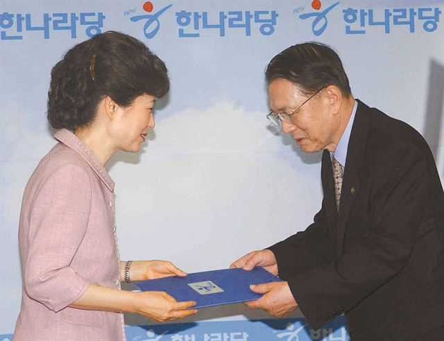 정수장학회 친목행사에 박근혜 대통령과 함께 참석한 김 전 비서실장이 박 대통령의 한나라당 대표 시절 여의도연구소장 임명장을 받고 있다. 한국일보 자료사진