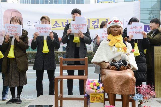 부산 평화의 소녀상 지킴이 발대식이 열린 18일 오후 부산 동구 일본영사관 후문에 세워진 소녀상 앞에서 부산 대학생 겨레하나 회원들이 한ㆍ일 정부를 비판하는 구호를 외치고 있다.