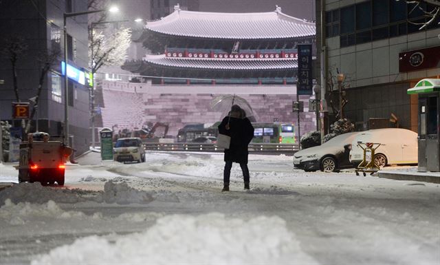 밤사이 많은 눈이 내린 20일 오전 서울 중구 세종대로 인근 이면도로에서 출근길 시민들이 발걸음을 재촉하고 있다. 김주영기자 will@hankookilbo.com