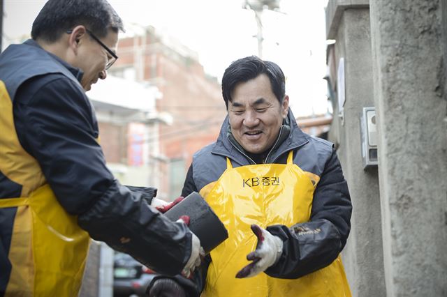 지난해 연말 사랑의 연탄 배달 활동에 나선 KB증권 임직원들이 연탄을 나르고 있다. KB증권 제공