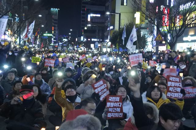 21일 대구 12차 시국대회에 참가한 시민들이 "박근혜는 즉각퇴진하라" 구호를 외치며 휴대전화 플래시 퍼포먼스를 펼쳤다. 윤희정기자 yooni@hankookilbo.com