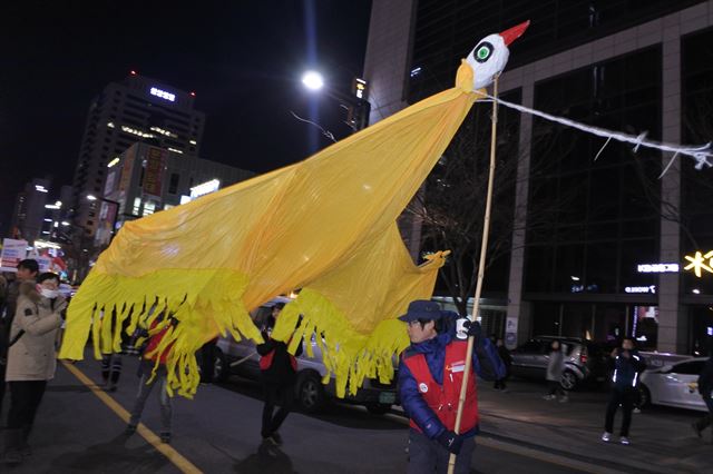 '박근혜 즉각퇴진'을 외치며 행진하는 시위대, '닭' 을 형상화한 천막이 선두로 걸어가고 있다. 윤희정기자 yooni@hankookilbo.com