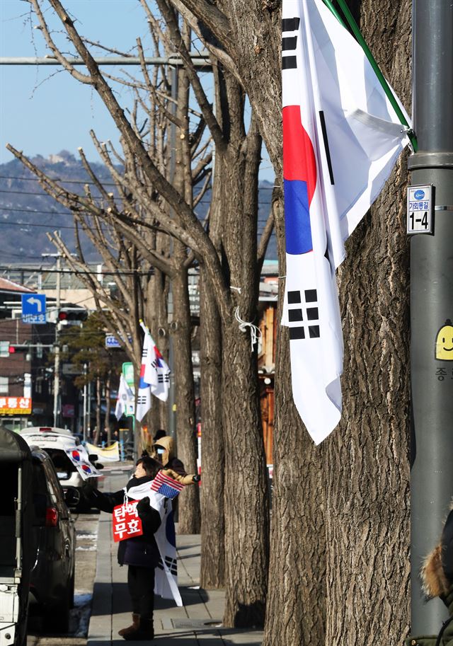 23일 서울 종로구 헌법재판소 앞 도로와 안국역 등 율곡로 일대에 의문의 태극기가 게양됐다. 연합뉴스