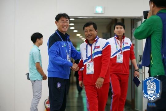 2014년 인천아시안게임 4강전을 앞둔 기자회견에서 윤덕여 한국 여자축구, 김광민 북한 감독이 반갑게 악수하는 모습. 대한축구협회 제공