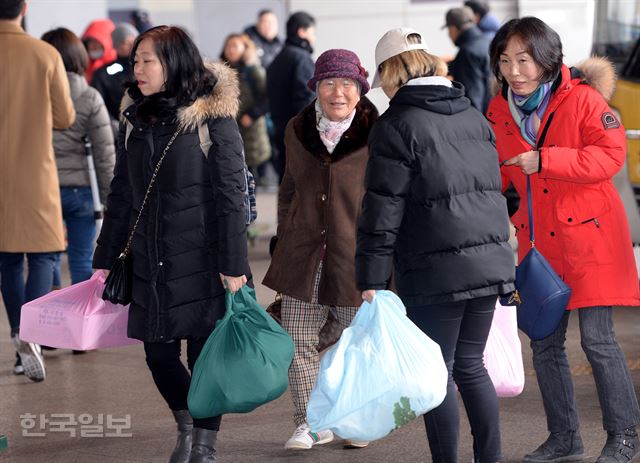 양손에 짐을 가득 들은 시민들이 하차장을 나서고 있다.