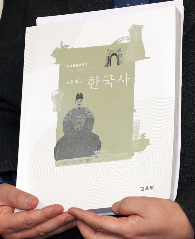 국회 교육문화체육관광위 더불어민주당 도종환 간사가 31일 오후 국회 정론관에서 열린 교육부의 국정교과서 최종본 발표와 관련한 민주당-국민의당 입장 발표 기자회견에서 최종본 교과서를 들고 있다. 연합뉴스