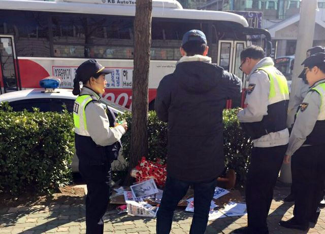 부산 일본영사관 앞 소녀상 철거를 요구하는 불법 부착물을 떼어낸 40대 남성이 경찰 조사를 받게 됐다. 3일 오전 11시 30분께 하모(41)씨가 부산 동구 일본영사관 앞 소녀상 주변에 붙은 다수의 종이 부착물을 떼 경찰이 출동해 조사하고 있다. 연합뉴스.