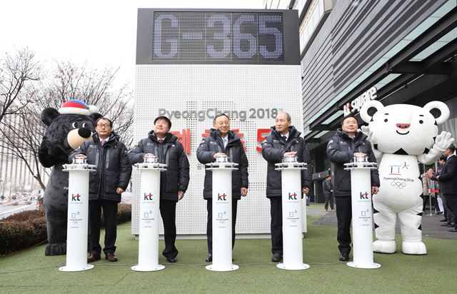 황창규(가운데) KT 회장과 임원들이 8일 서울 광화문 KT 사옥 앞에서 평창동계올림픽까지 남은 날짜를 알려주는 전광판을 점등하고 있다. KT 제공