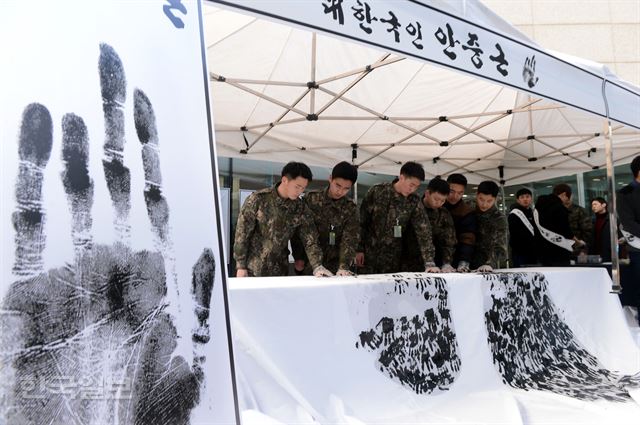 13일 오전 서울 용산구청 아트홀에서 군인들이 안중근 의사 사형선고일을 기리기 위해 마련된 손도장 찍기 행사에 참여해 자신의 손도장을 종이에 새기고 있다.고영권기자 youngkoh@hankookilbo.com