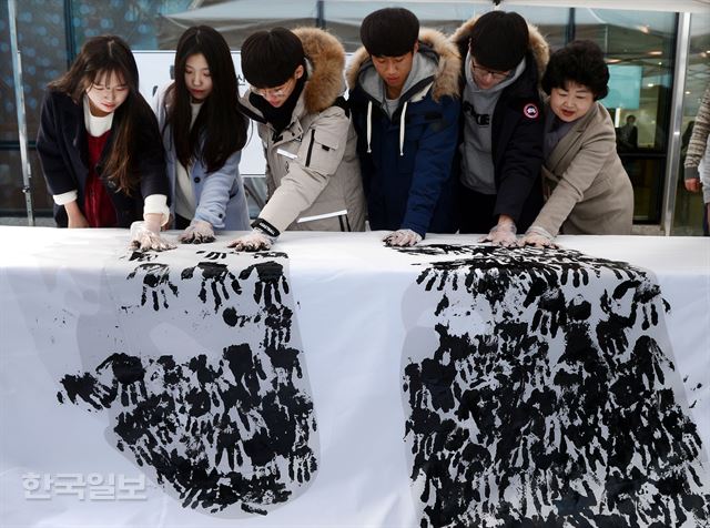 13일 오전 용산구청 아트홀에서 시민들이 안중근 의사 사형선고일을 기리기 위해 마련된 손도장 찍기 행사에 참여해 자신의 손도장을 종이 위에 새기고 있다.고영권기자 youngkoh@hankookilbo.com