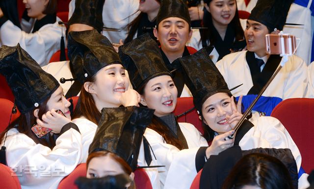 13일 오전 서울 흑석동 중앙대에서 열린 예술대학 전통예술학부 졸업식서 조선시대 선비복식인 '학창의'를 입은 졸업생들이 셀카로 사진을 찍으며 즐거워 하고 있다.고영권기자 youngkoh@hankookilbo.com