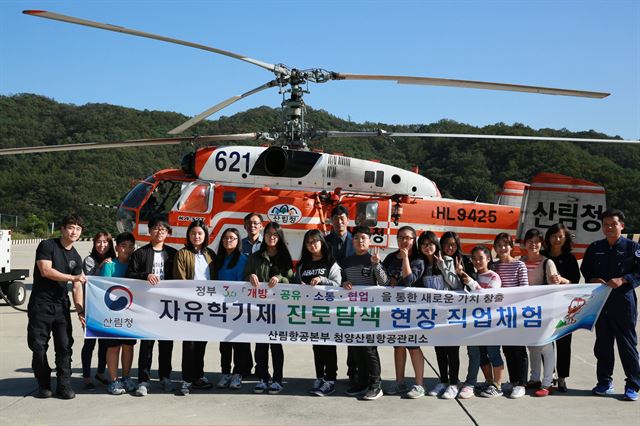 산림청이 지난해 실시한 자유학기제 프로그램에 참가한 학생들이 대형 산불진화헬기 앞에서 기념사진을 찍고 있다. 산림청 제공