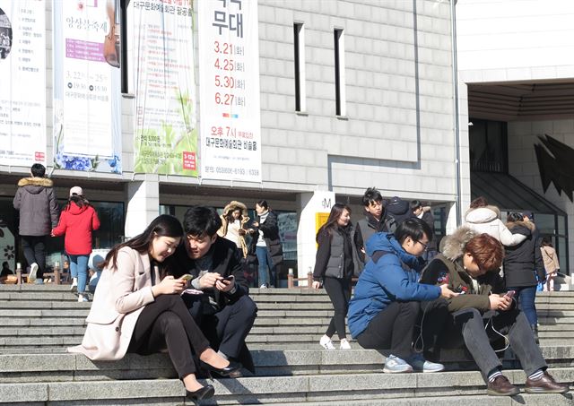 시민들이 대구 달서구 대구문화예술회관 팔공홀 앞 계단에 앉아 포켓몬고를 즐기고 있다. 이 계단은 포켓몬고 '성지'인 문예회관 안에서도 명당으로 손꼽히는 지점으로, 3개의 포켓스톱이 교차하고 있어 유저들의 인기가 높다. 정광진기자 kjcheong@hankookilbo.com