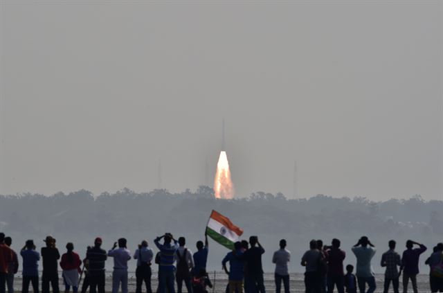 인도 스리하리코타에서 15일(현지시간) 인도 우주개발기구(ISRO)가 자체개발한 PSLV-C37 로켓 1개로 지구관측 위성 카르토샛-2 등 3개의 인도 위성과 미국, 이스라엘, 카자흐스탄, 네덜란드, 스위스, 아랍에미리트(UAE) 등 6개국 위성 101를 포함한 총 104개의 위성을 발사하는 데 성공한 가운데 시민들이 위성발사 모습을 바라보고 있다.로이터 뉴스1