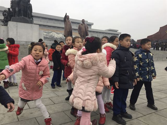 김정은 국무위원장의 이복형 김정남이 피살된 지 나흘 째를 맞았으나 북한 당국이 침묵하고 있는 가운데 김정일 생일(광명성절) 75돌을 맞은 16일(현지시간) 평양에서 밝은 표정의 어린이들이 만수대 언덕을 방문해 헌화를 기다리고 있다. AP 연합뉴스