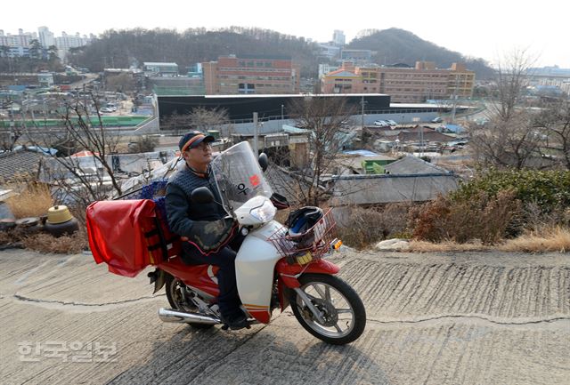 15일 오후 2시 인천 옥련동 옥골마을에서 우체국 집배원이 가파른 언덕길을 오르며 우편을 배달하고 있다. 인천=홍인기 기자