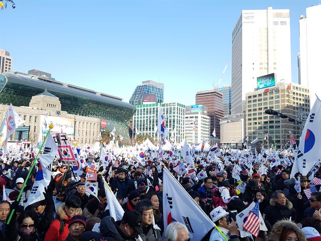 18일 오후 서울 중구 대한문 앞에서 탄핵반대 집회에 참석한 보수단체 회원들이 태극기와 성조기를 흔들고 있다. 정반석 기자