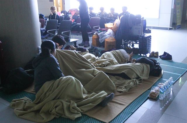 19일 오후 제주국제공항 2층 대합실에 항공기 결항으로 제주를 떠나지 못한 승객들이 매트 위에 누워 밤을 지새고 있다. 한국공항공사 제주지역본부는 이날 제주공항 대합실에 남은 체류객을 120여명으로 파악했다. 뉴시스